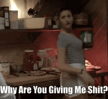 a woman standing in a kitchen with the words " why are you giving me shit "