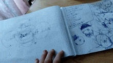 a person is holding a book with drawings on it and one of the drawings says emma