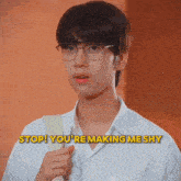 a young man wearing glasses and a white shirt says " stop you 're making me shy "