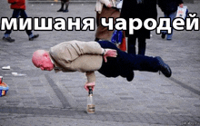 a man is doing a handstand on the ground with a bottle of alcohol .