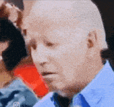 a close up of a man 's face with a blue shirt and tie