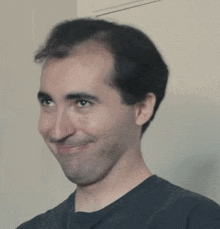 a man wearing a black shirt is making a face