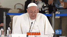a man sitting in front of a microphone with the word inchiana on the screen