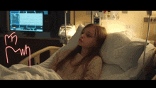 a girl is laying in a hospital bed with a monitor behind her that says ' i 'm mwn '