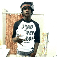 a man wearing a black and white shirt that says lead over low leaders