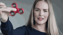 a woman holding a red fidget spinner in her hand