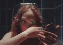 a woman is looking at herself in a mirror in a bathroom