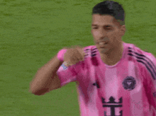 a soccer player wearing a pink shirt with the letter t on it