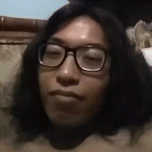a close up of a person 's face with glasses and long hair