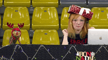a woman wearing a santa hat sits at a desk with a sign that says bon nadal