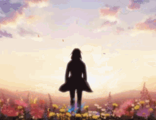 a silhouette of a woman standing in a field of flowers at sunset