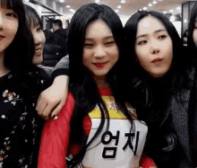 a group of young women are posing for a picture and one of them is wearing a red shirt with the number 7 on it