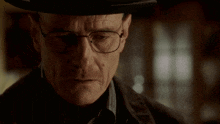 a man with glasses and a hat looks down