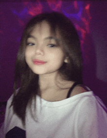 a girl in a white shirt is looking at the camera