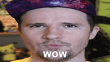 a man wearing a galaxy hat says wow on his face .