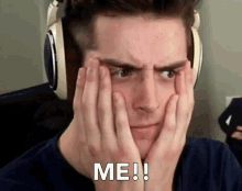 a man wearing headphones covering his face with his hands and the words me written on his face