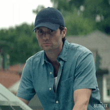 a man wearing a blue hat and a denim shirt with netflix on the bottom