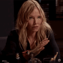 a woman sitting at a table with nbc written on the bottom
