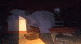 a person is laying down in a dark room with a light shining on them