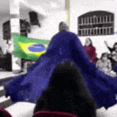 a woman in a blue dress is dancing in front of a group of people .
