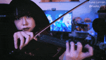 a woman is playing a violin with the name luna lorraine on the bottom
