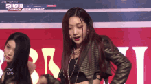 a woman in a leather jacket is dancing on a stage in front of a banner that says show champion