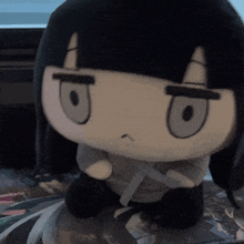 a stuffed animal with black hair and gray eyes looks angry
