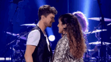 a man and a woman looking into each other 's eyes on a stage