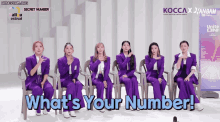 a group of women in purple suits are sitting in front of a screen that says what 's your number !