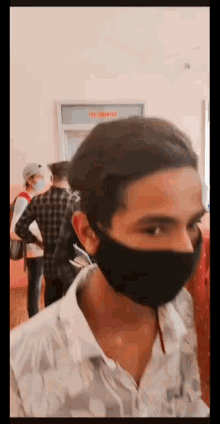 a man wearing a black face mask is standing in front of a sign that says fee commissioner