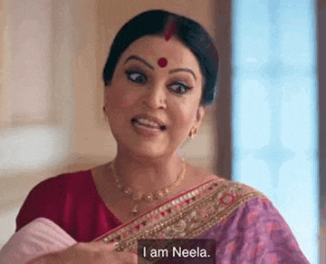 a woman in a red sari is holding a baby and saying `` i am neela . ''