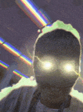 a man with glowing eyes is standing in front of a rainbow