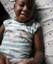 a little girl wearing a striped shirt with a bike on it