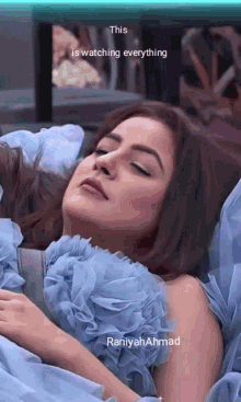 a woman in a blue dress is laying on a bed with her eyes closed ..