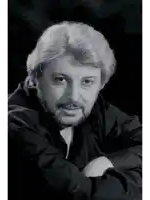 a black and white photo of a man with a beard wearing a black shirt