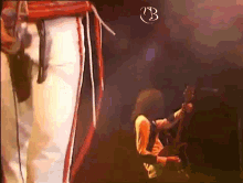 a person playing a guitar with the letter b on the bottom left