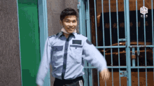 a man wearing a mask is standing in front of a blue fence