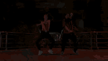 a man is dancing in a dark room with a red light behind him .