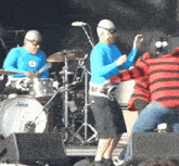 a drummer wearing a blue shirt with a smiley face on it