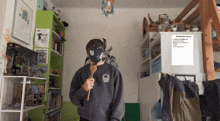 a person wearing a mask and a sweatshirt that says ' playstation spine ' on it