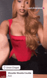 a woman in a red top is taking a picture of herself