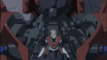a man in a red scarf sits in the cockpit of a machine