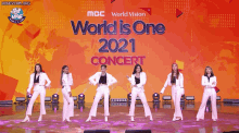 a group of women are dancing on stage in front of a sign that says world is one 2021 concert