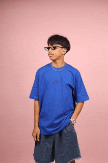 a man wearing a blue nike shirt and sunglasses