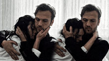 a man in a suit is hugging a woman in a white shirt with black nails