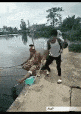a man with a backpack is fishing in a lake while another man sits on the shore