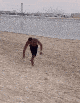 a shirtless man standing on a beach with the words mounir moons written below him