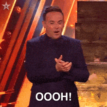 a man in a suit and bow tie is clapping and saying oooh !