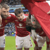 a group of soccer players are standing on a field and one of them has the number 2 on their shorts