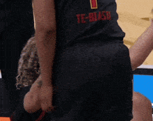 a person wearing a black te-biasu shirt